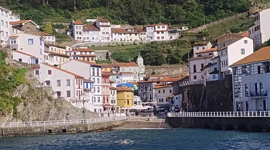 Pueblo de Cudillero en Asturias, con casas de colores colgadas en la ladera de la montaña frente al mar Cantábrico