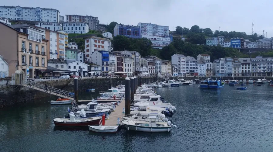 Puerto de Luarca en Asturias, con barcos amarrados y casas de colores en las laderas que rodean la villa marinera