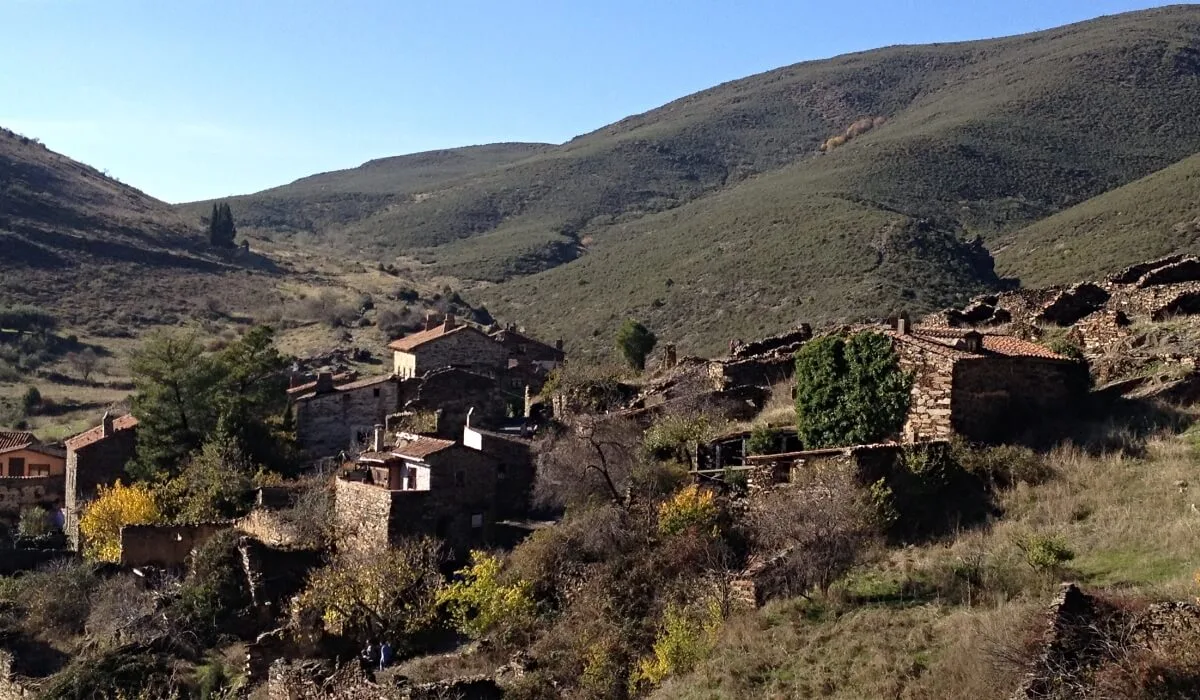 Vista panorámica de Patones de Arriba, pueblo de la Sierra Norte de Madrid, con sus casas de pizarra integradas en el paisaje montañoso.