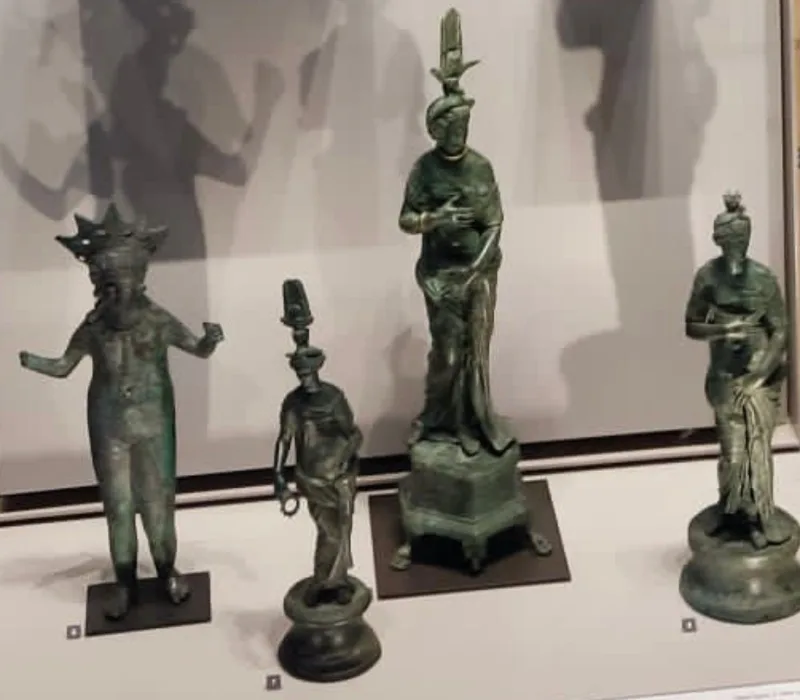 Estatuillas votivas de bronce de dioses egipcios como Osiris, Isis y Horus, expuestas en el Museo del Louvre.