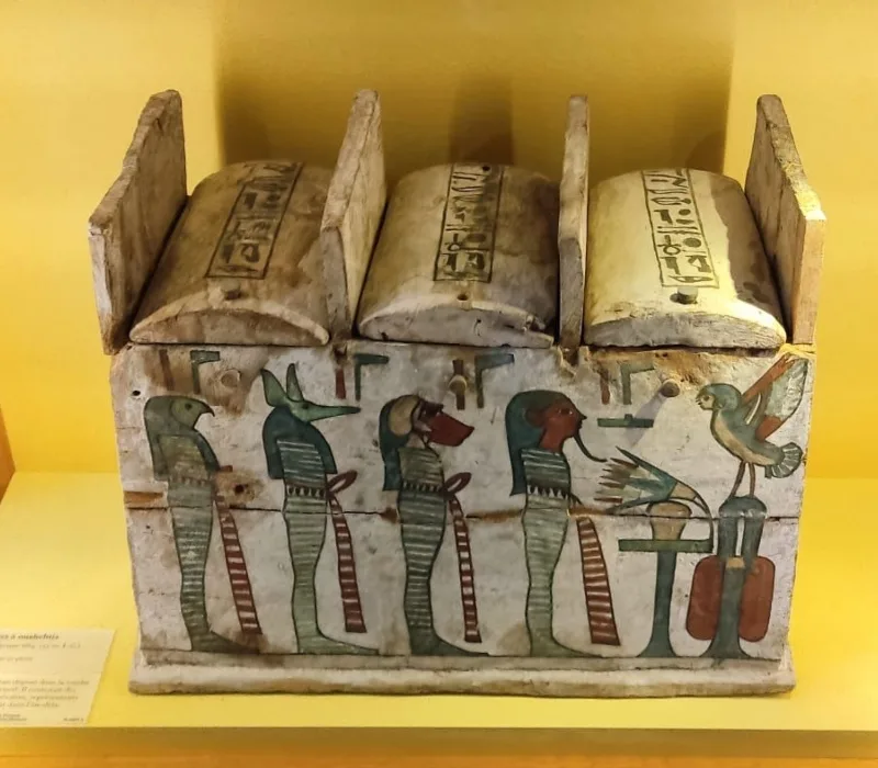 Cofre canópico del Antiguo Egipto decorado con deidades protectoras, exhibido en el Museo del Louvre.