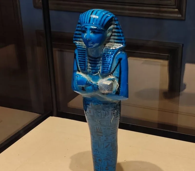 Figura ushabti de cerámica azul del Antiguo Egipto, exhibida en el Museo del Louvre.