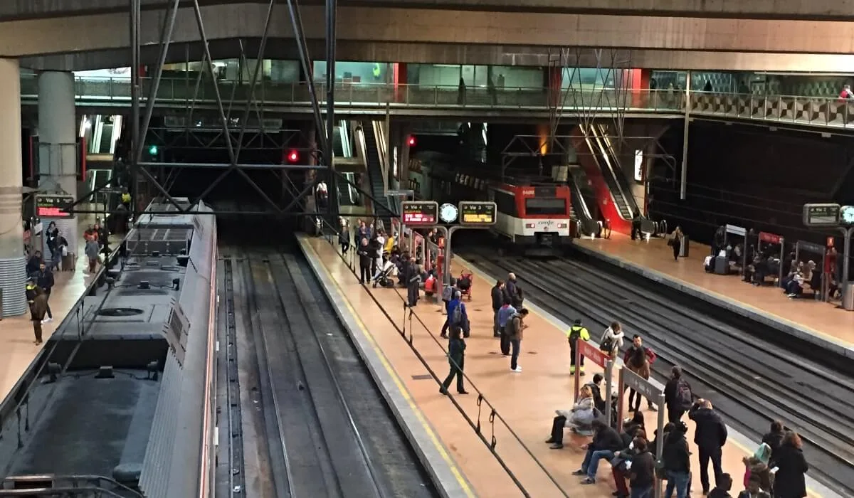 Estación de Atocha Madrid interior de andenes con trenes de Cercanías y pasajeros esperando