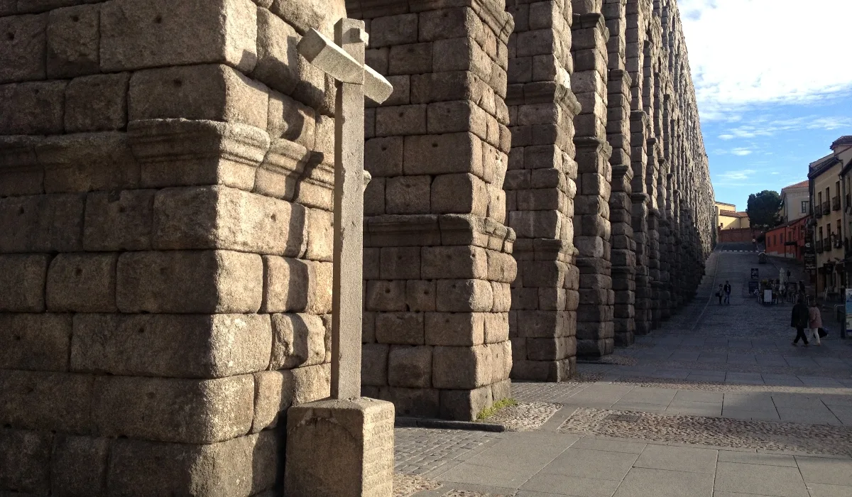 Detalle de los pilares del Acueducto de Segovia en la plaza del Azoguejo, con la luz del atardecer resaltando la piedra romana