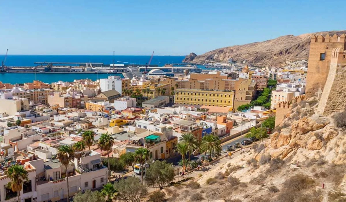 Vista panorámica de Almería con la Alcazaba en primer plano, el puerto y el mar Mediterráneo al fondo bajo un cielo despejado