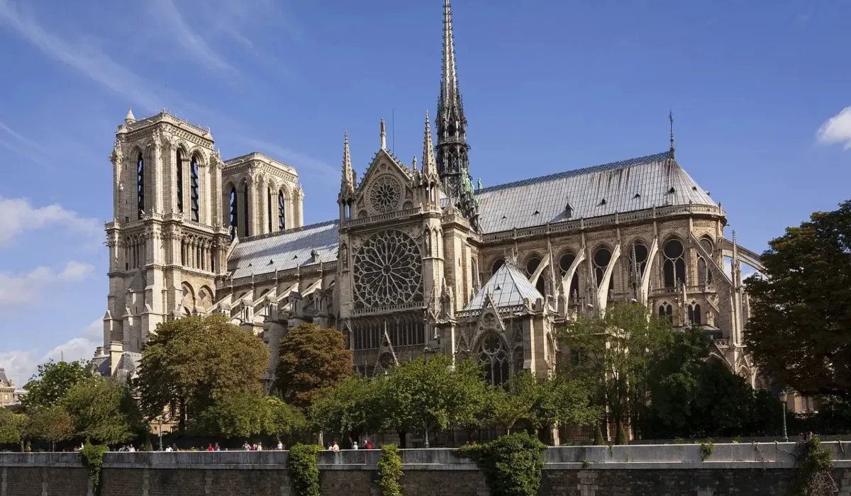 Catedral de Notre Dame de París vista desde el río Sena, con la fachada gótica, el rosetón central y la aguja sobresaliendo bajo cielo azul