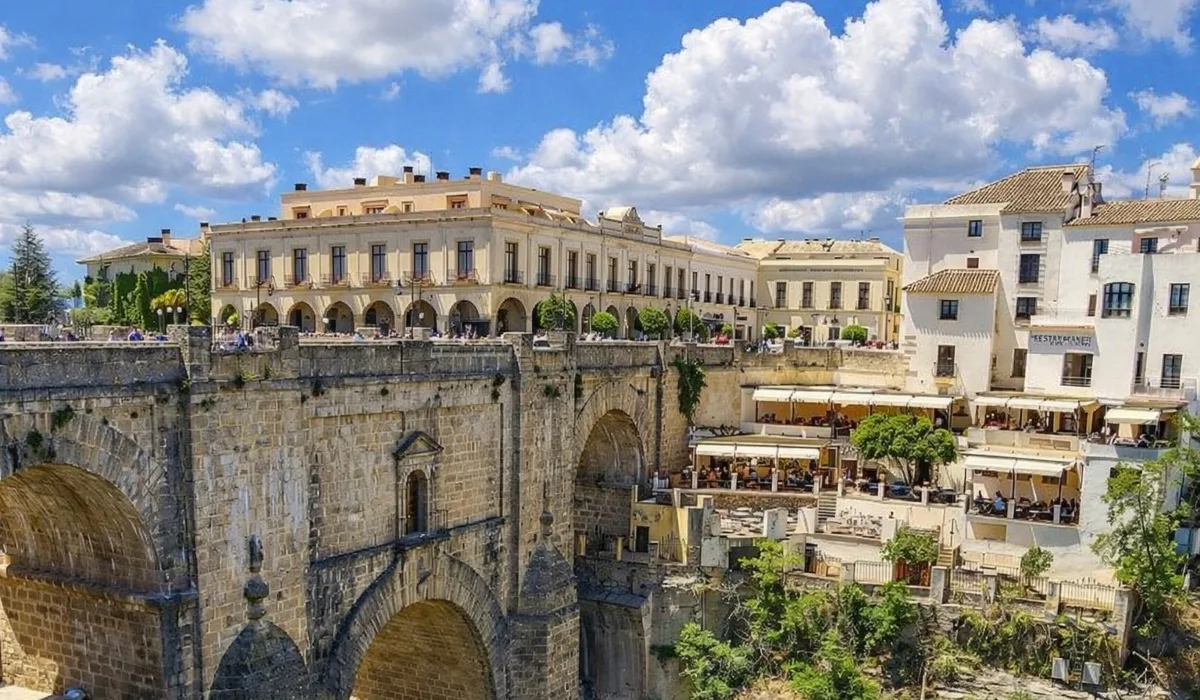 Puente Nuevo de Ronda sobre el Tajo, vista panorámica con casas blancas y cielo azul con nubes