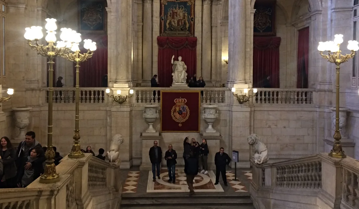 Escalera de honor del Palacio Real de Madrid con escudo de España y esculturas de leones