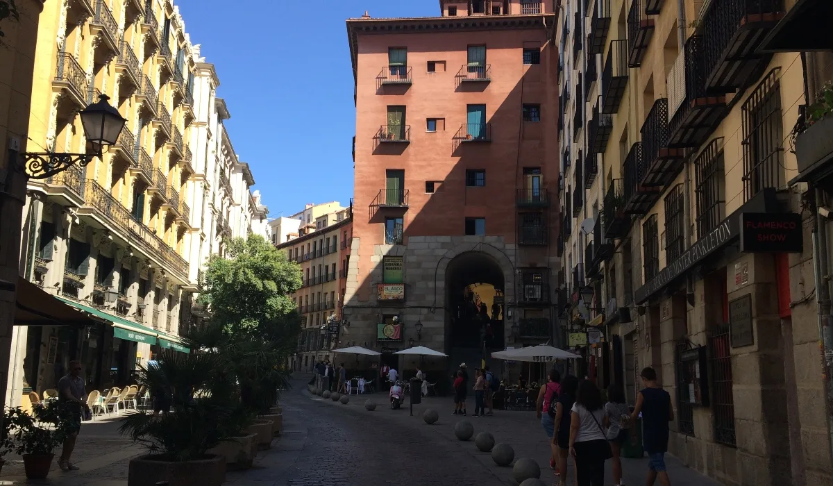 Arco de Cuchilleros en el Madrid de los Austrias, con edificios históricos y terrazas en una calle peatonal del centro de Madrid