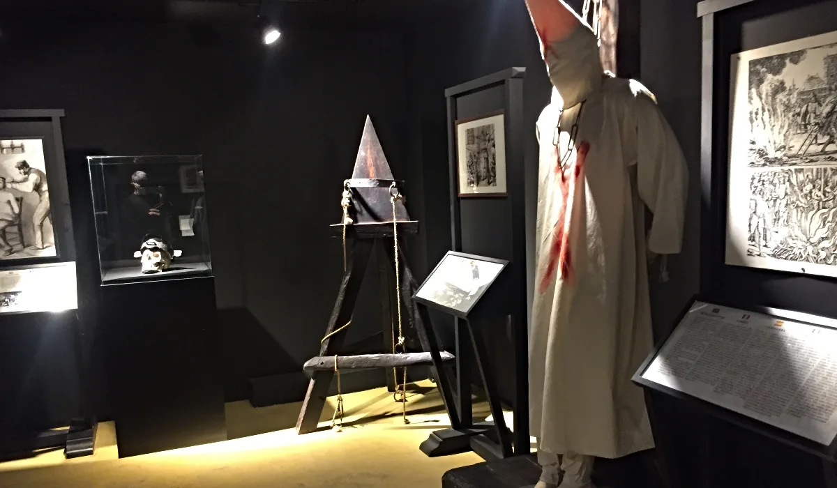 Sala del Museo de la Tortura con instrumentos medievales de castigo y paneles históricos en Santillana del Mar