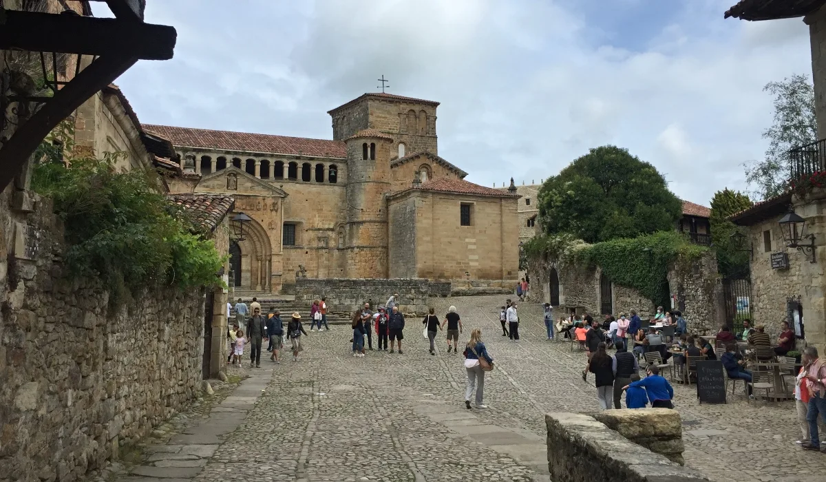 Plaza frente a la Colegiata de Santa Juliana en Santillana del Mar Cantabria con visitantes y arquitectura románica