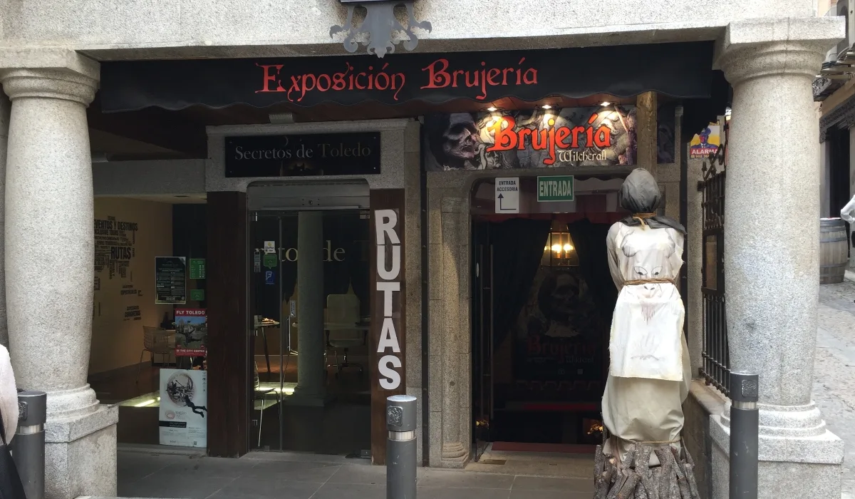 Entrada del Museo de la Brujería en el casco histórico de Toledo con cartel Exposición Brujería y figura de bruja en la puerta