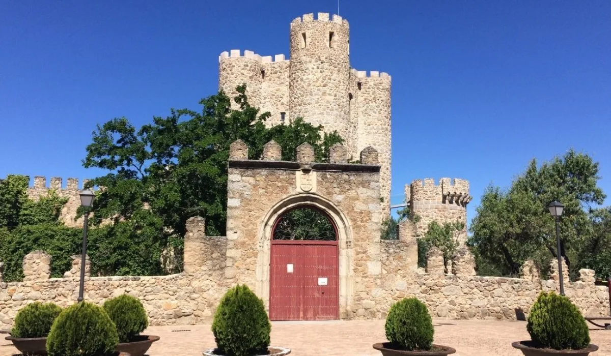 Vista del Castillo de la Coracera en San Martín de Valdeiglesias, fortaleza medieval de la Comunidad de Madrid con torres de piedra y acceso amurallado.