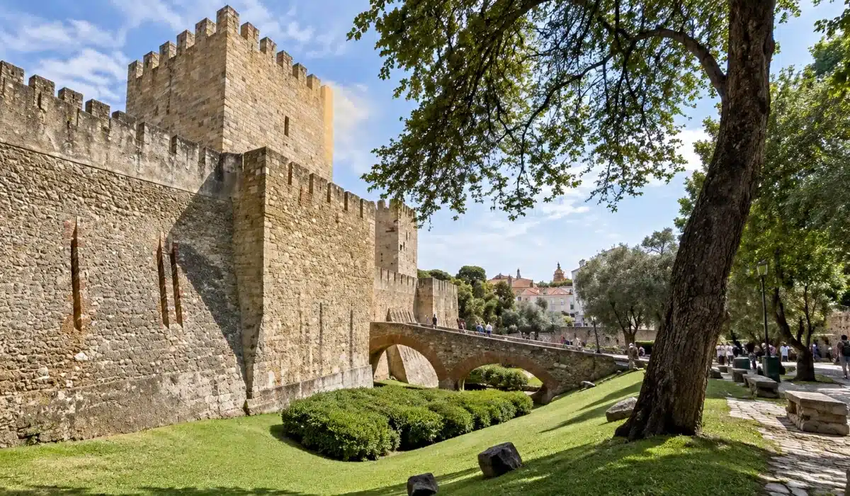 Vista panorámica del Castillo de San Jorge y el barrio de Alfama en Lisboa, con tejados tradicionales y ambiente histórico realista bajo un cielo nublado